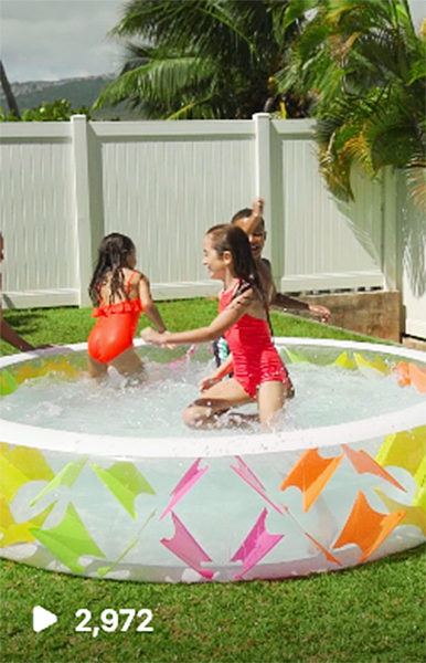 a group of kids running around a backyard pool