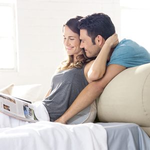 a couple relaxing on an inflatable air mattress with a headboard
